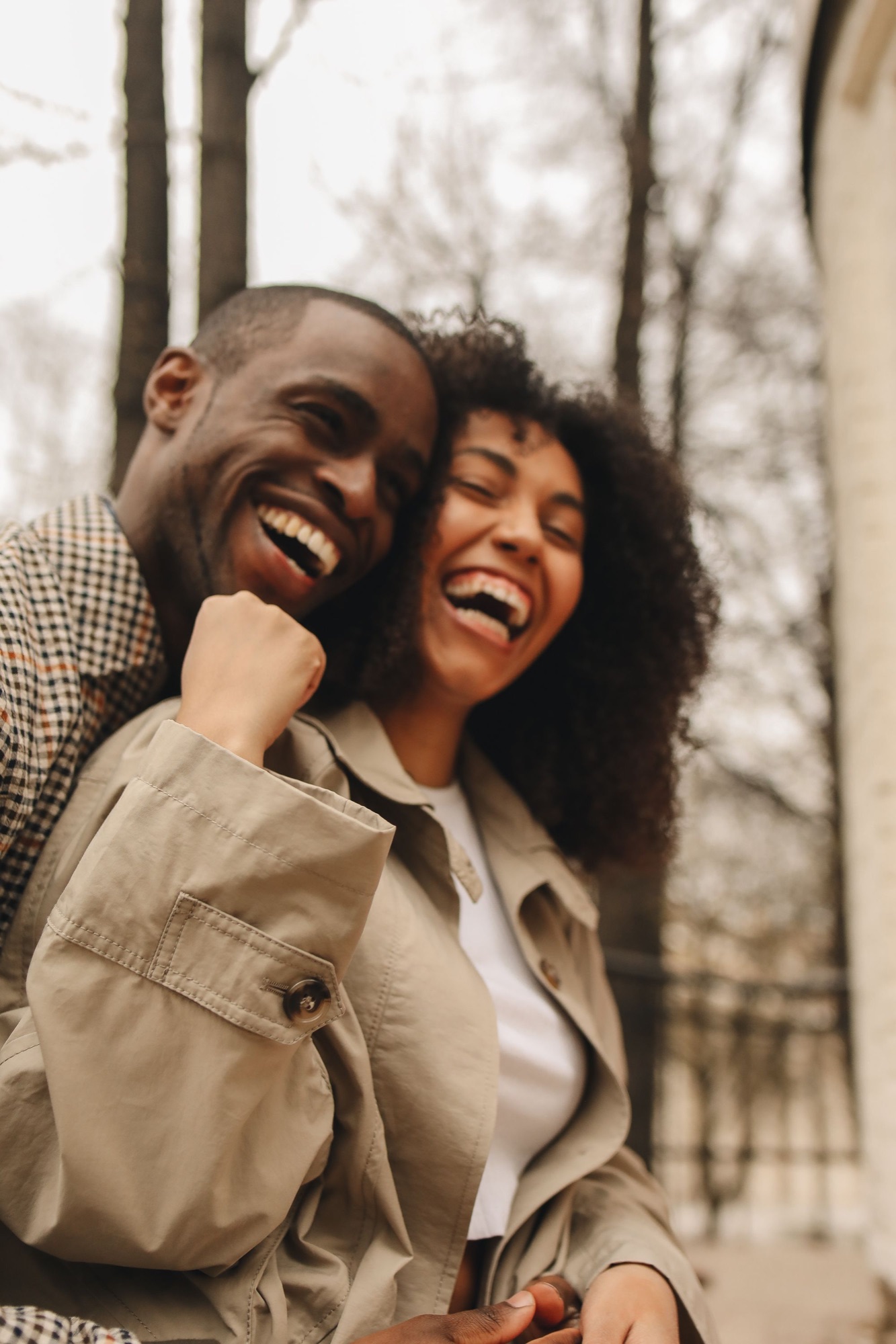 A joyful Black couple laughing and embracing